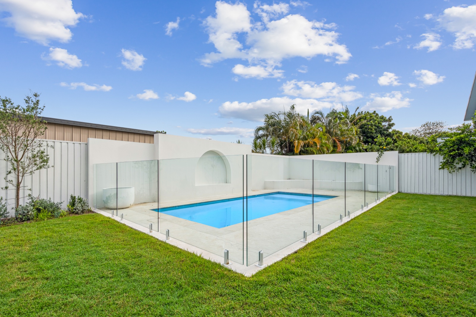 Pool and lawn behind glass fencing